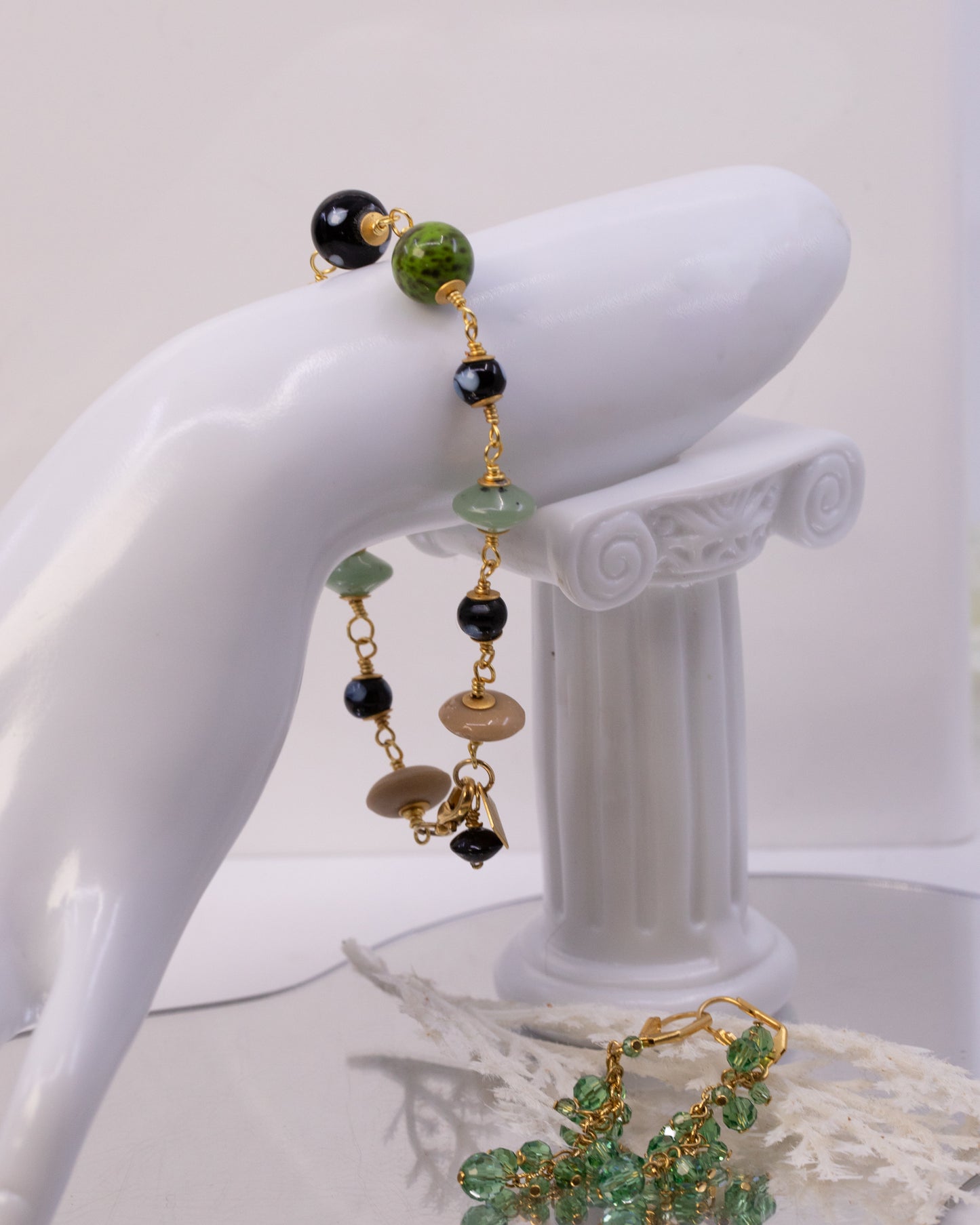 Bracelet with green and black beads on a white mannequin arm