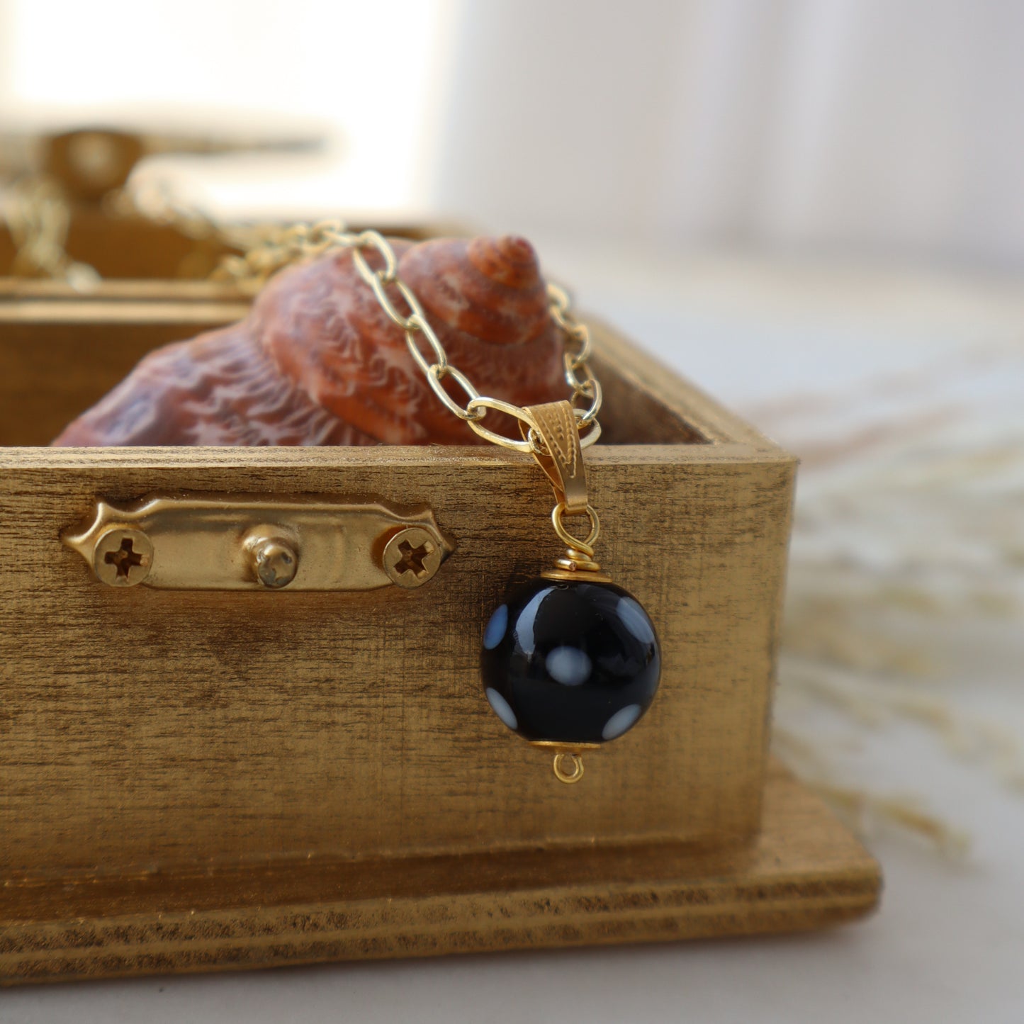 Necklace with a black bead pendant on a wooden box
