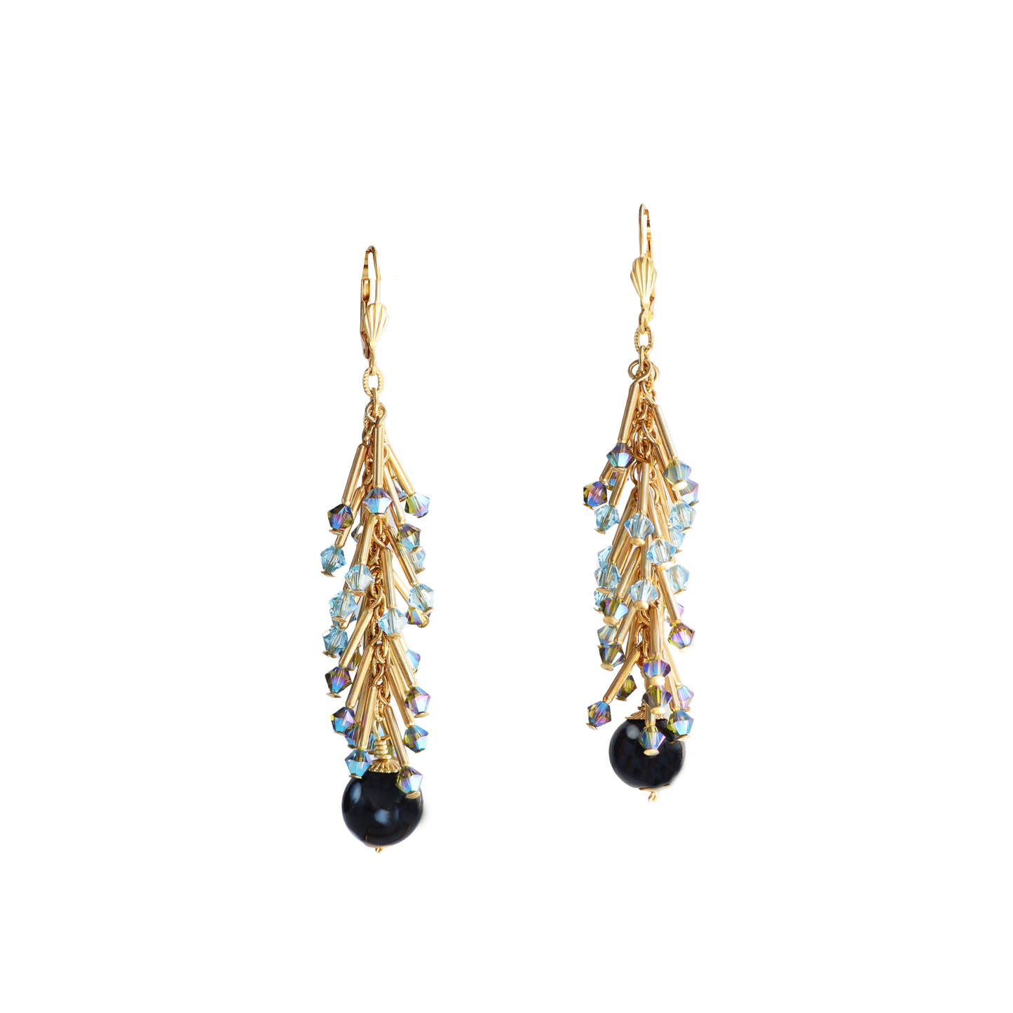 Gold earrings with black and blue gemstones on a white background