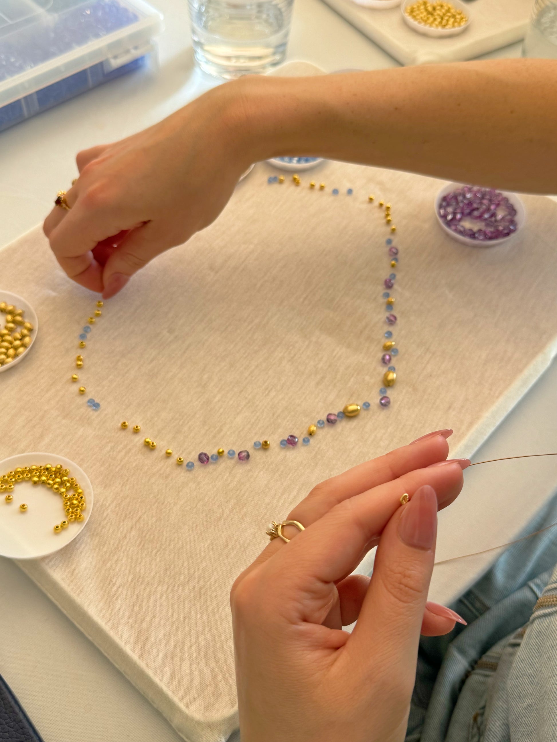 Close-up of necklace assembly with purple beads during NYC necklace workshop