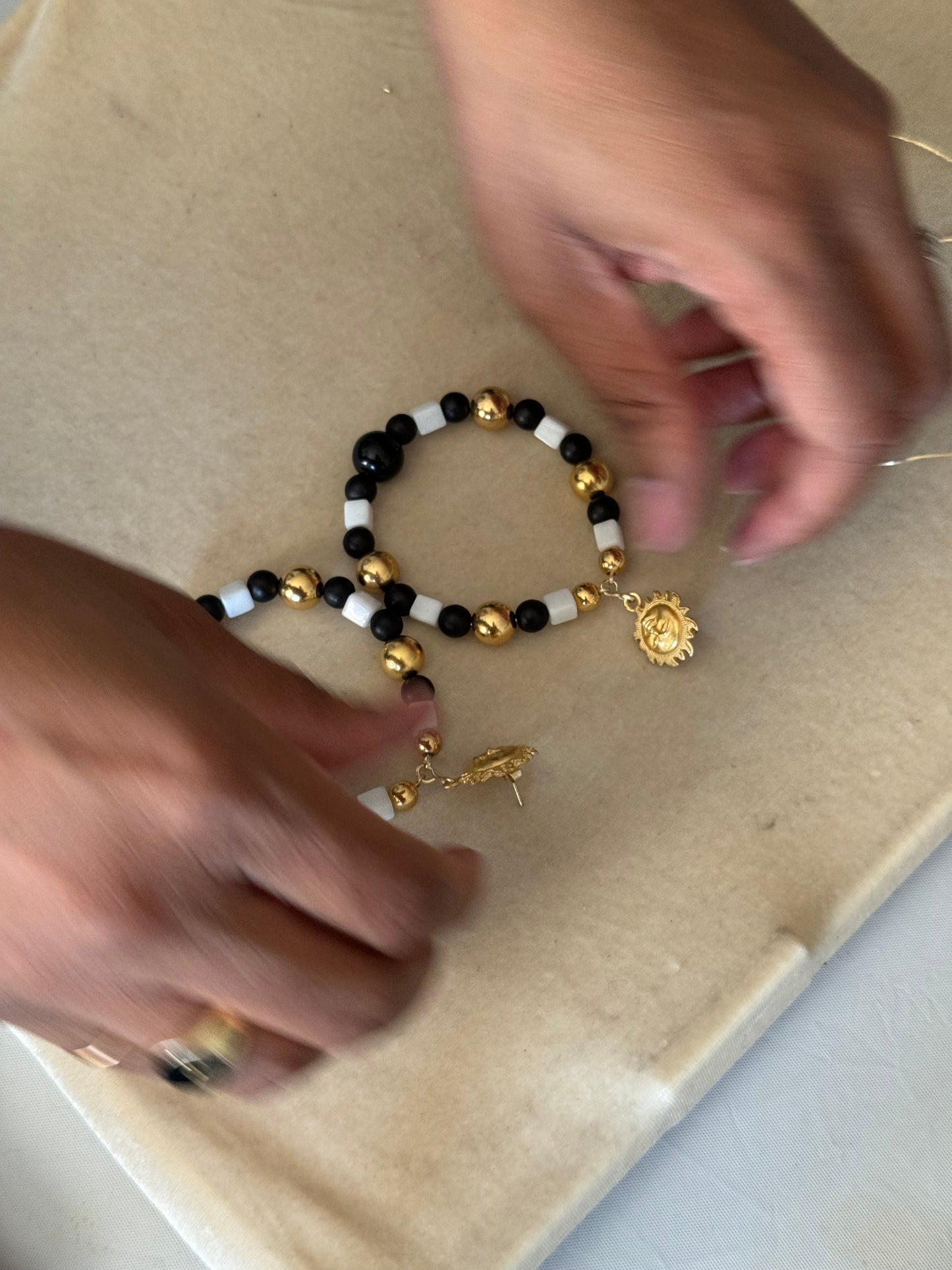 Two pairs of completed beaded earrings displayed on a hand during a DIY class