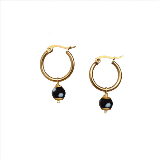 Gold hoop earrings with black beads on a white background. evil eyes, handmade jewelry. New York. Unique jewelry