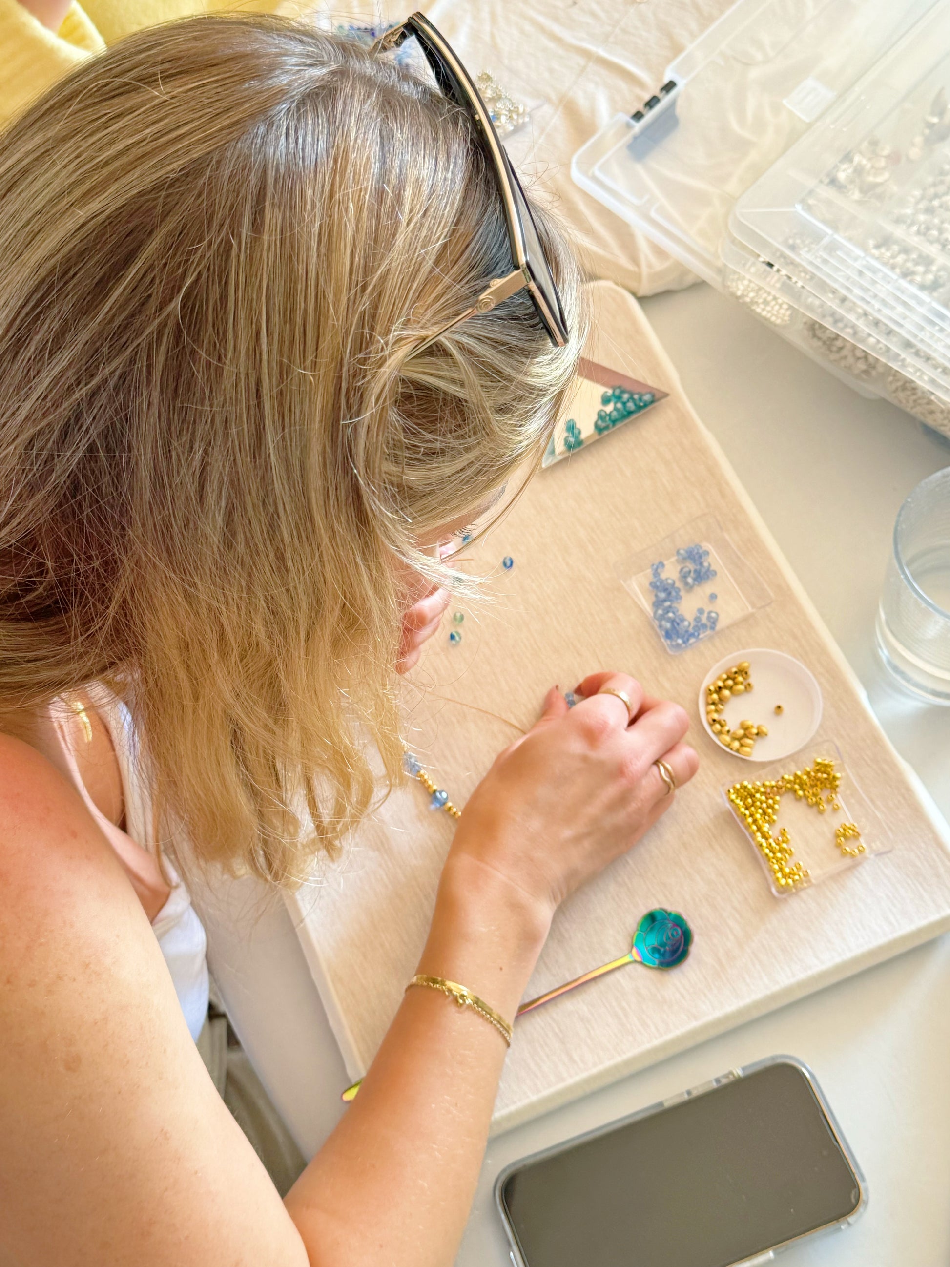 Woman designing a handmade necklace using colorful beads at a jewelry making workshop