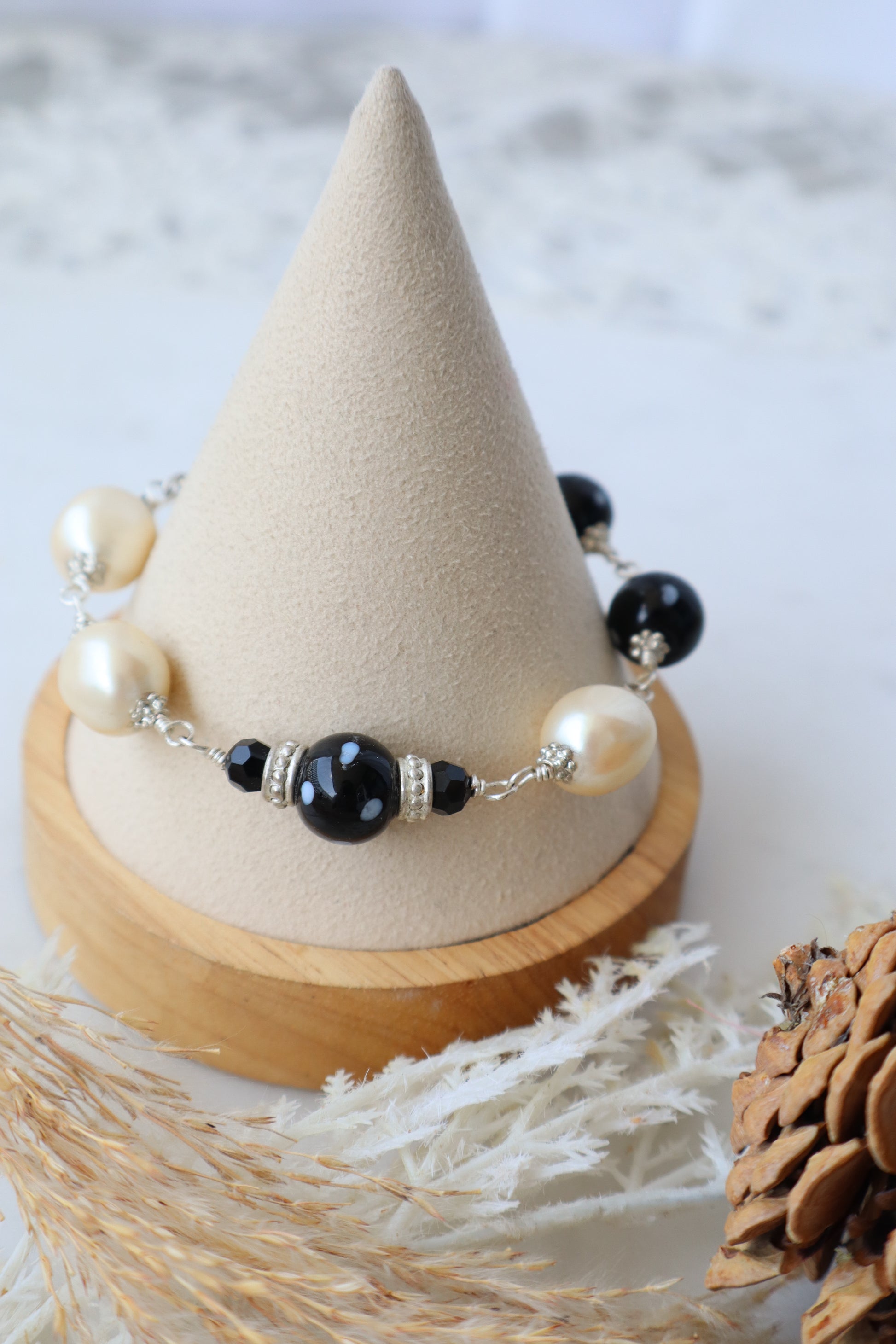 Beaded earring on a wooden cone with a natural background