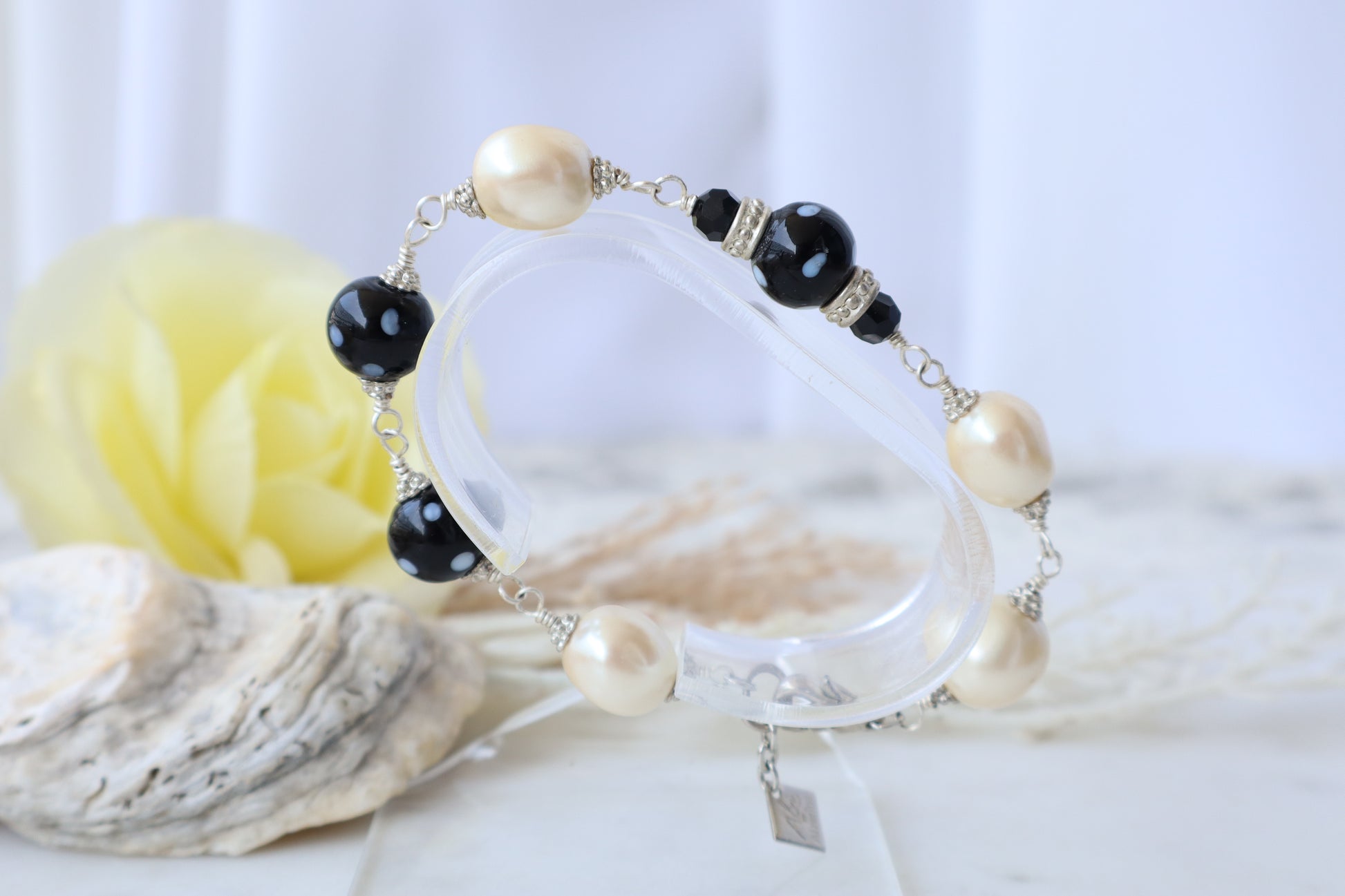 Bracelet with pearls and black beads on a white background