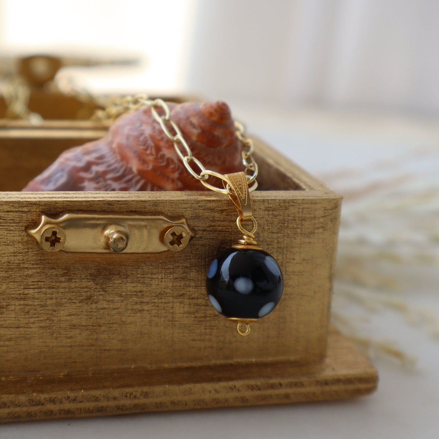 Necklace with a black bead pendant on a wooden box