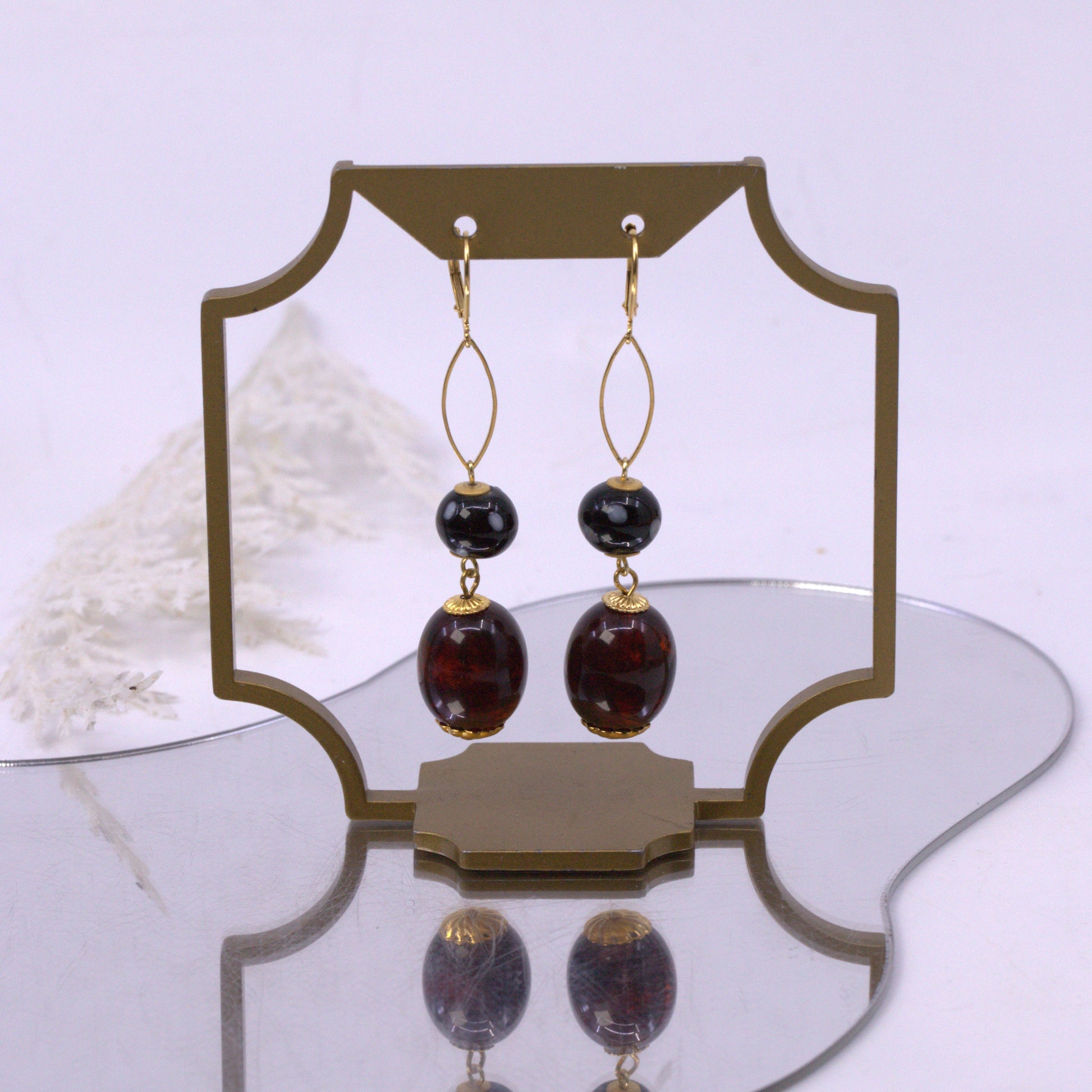 Pair of earrings with gold and brown stones on a white background