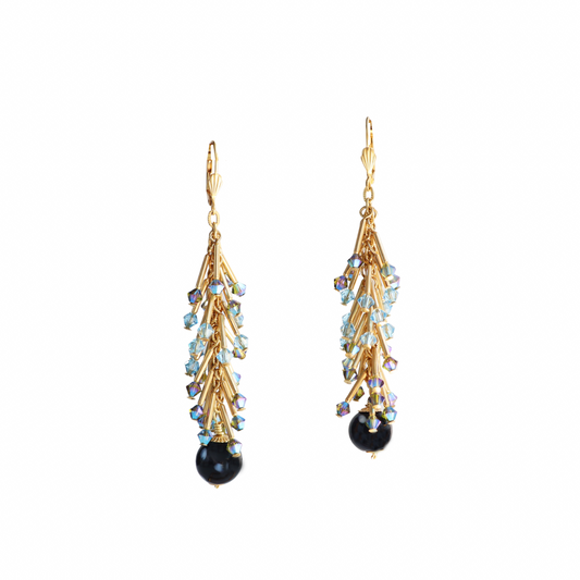 Gold earrings with black and blue gemstones on a white background