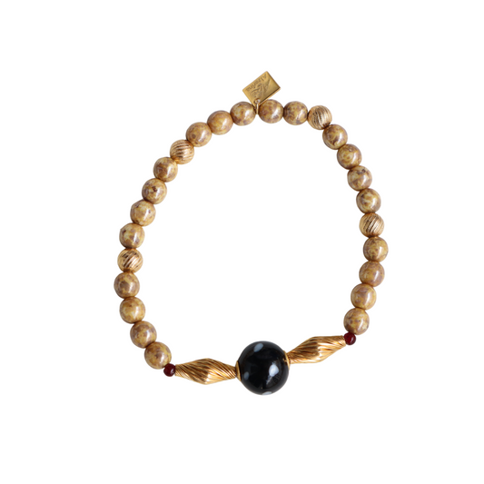 Beaded bracelet with a black bead on a white background