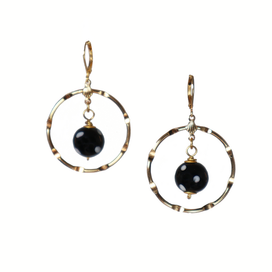 Pair of earrings with gold circular designs and black beads on a white background