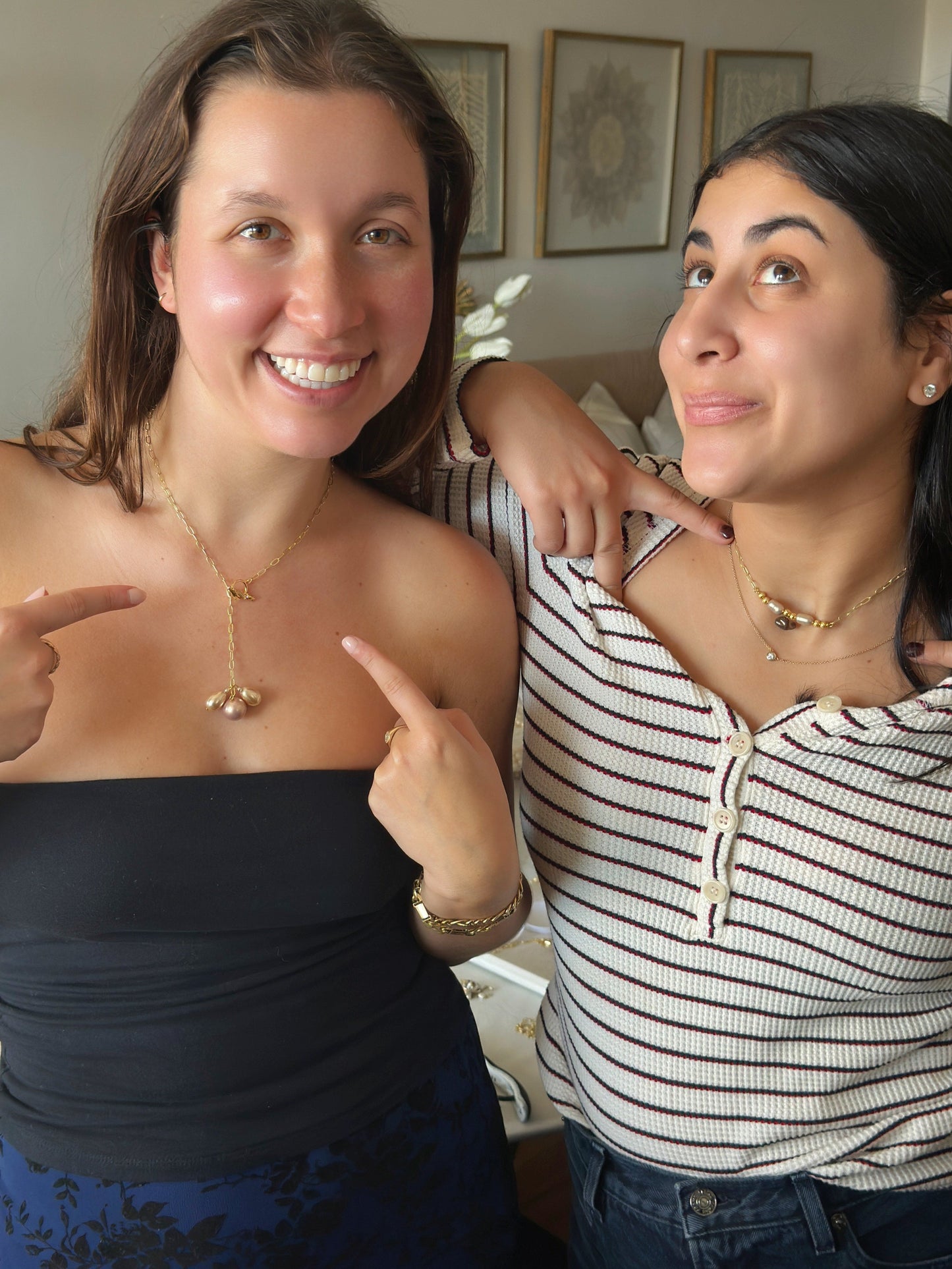 Two friends showing off their handmade jewelry necklaces
