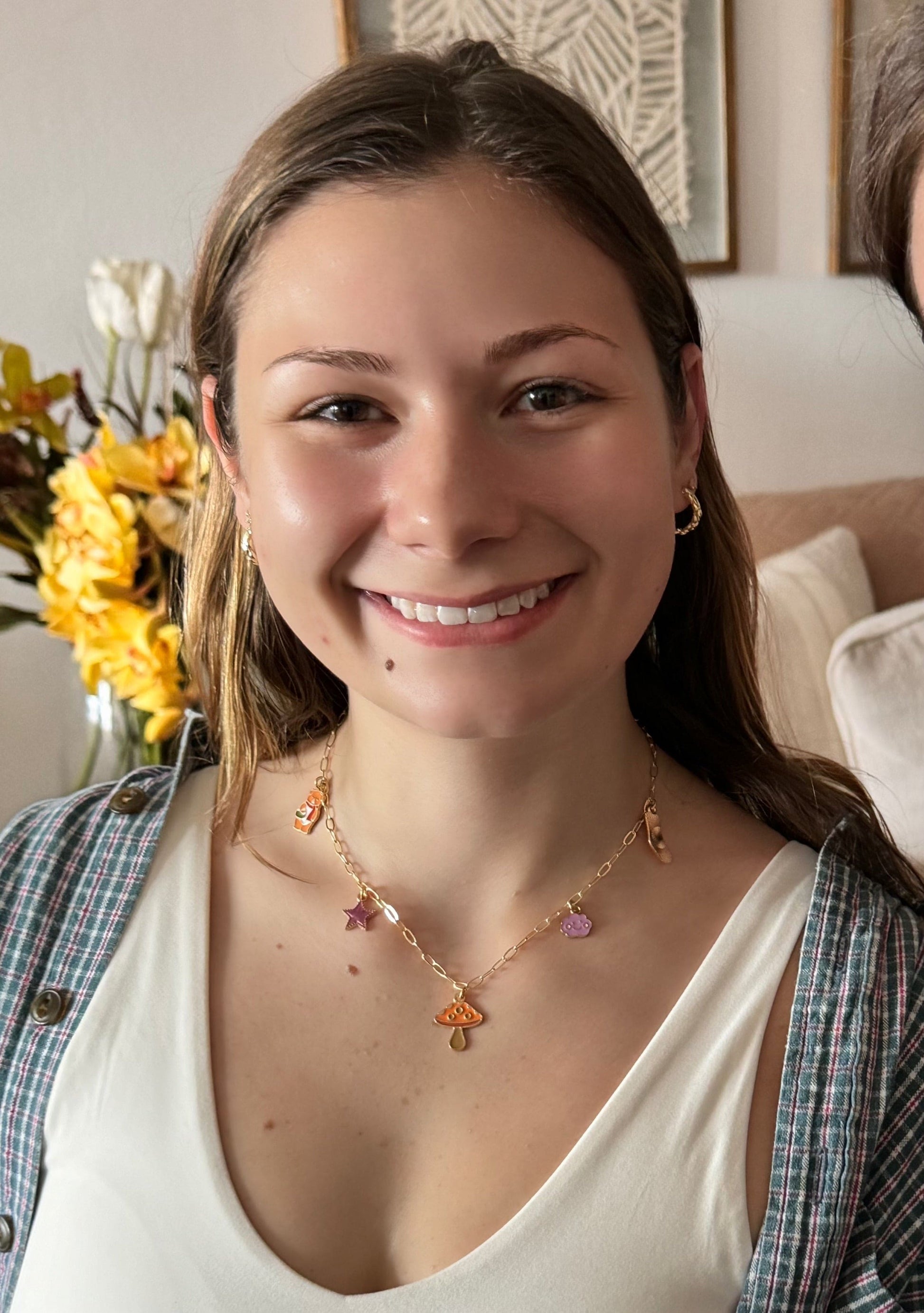 Girl smiling and wearing her handmade necklace
