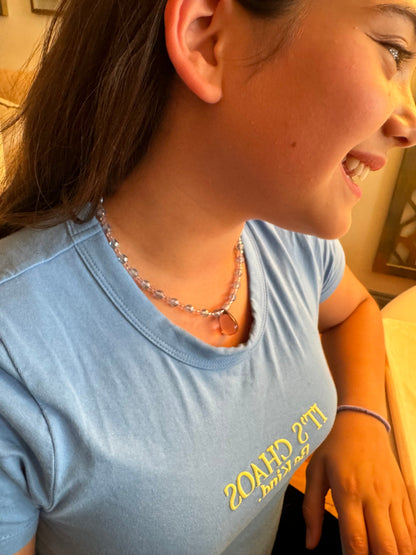 Girl smiling while trying on her beaded necklace
