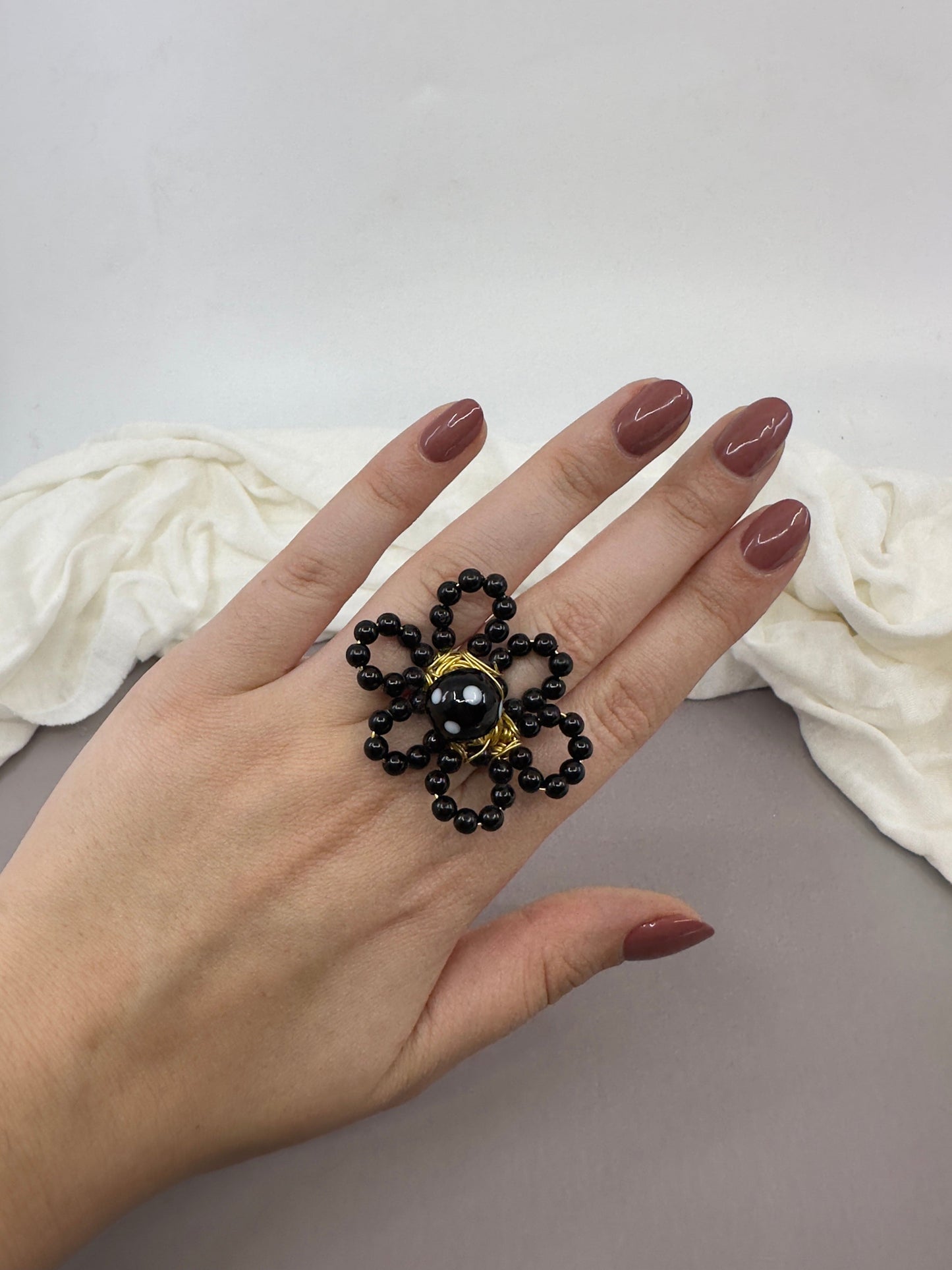 Close-up of a handmade flower ring on a child’s hand
