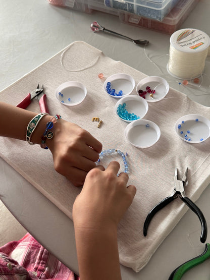 Children selecting beads and tools at the jewelry-making table
