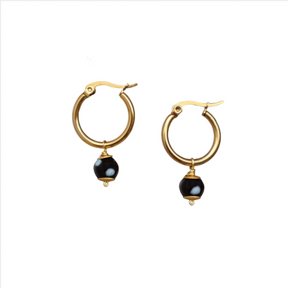 Gold hoop earrings with black beads on a white background. evil eyes, handmade jewelry. New York. Unique jewelry