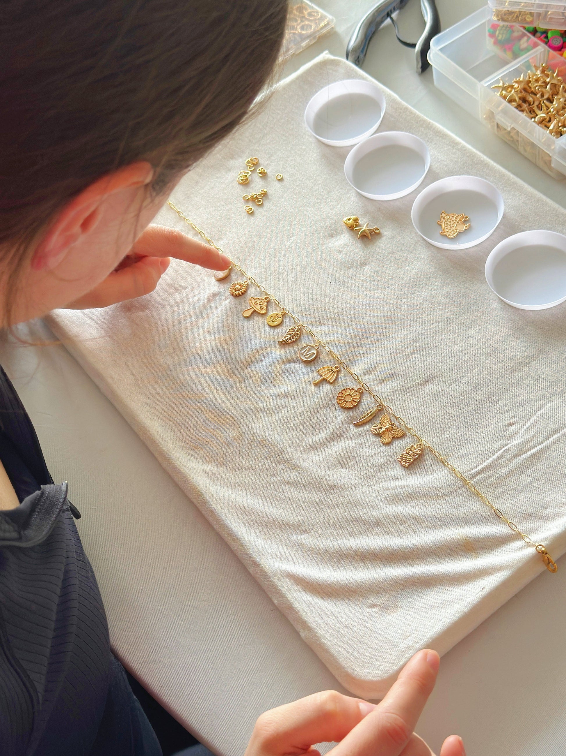 Student focused on assembling jewelry on workspace
