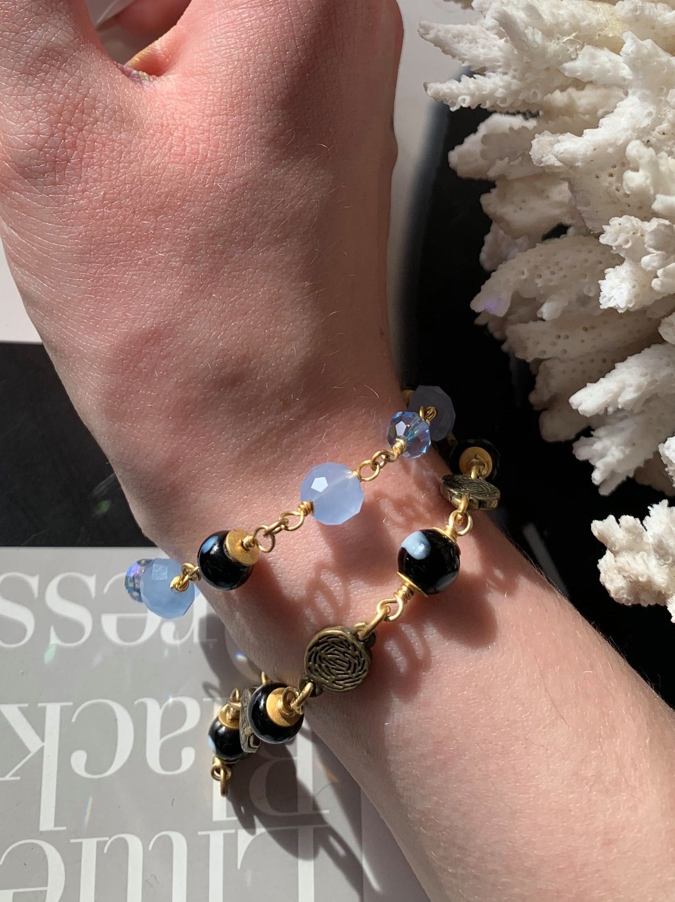 Saudade bracelet worn on wrist, showcasing black and gold bead details